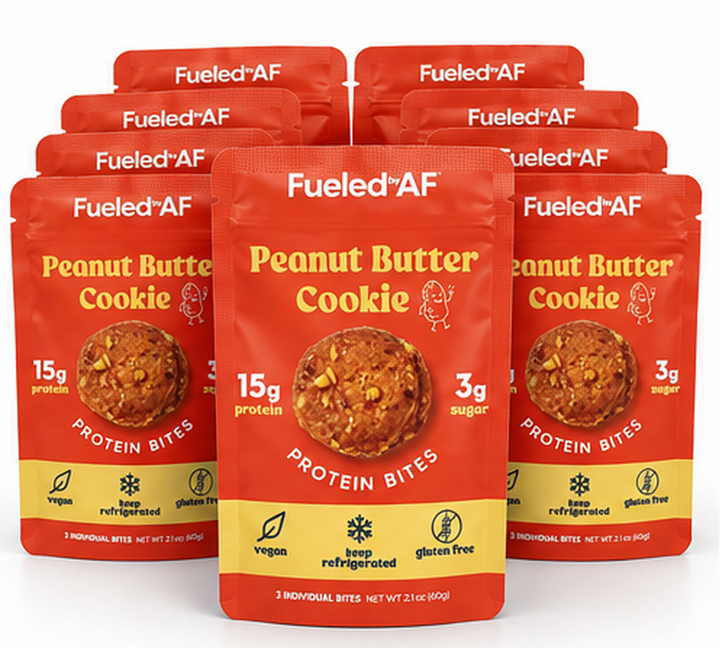 Six red and yellow Fueled+AF Peanut Butter Cookie Protein Bites pouches arranged in a fan shape on a white background.