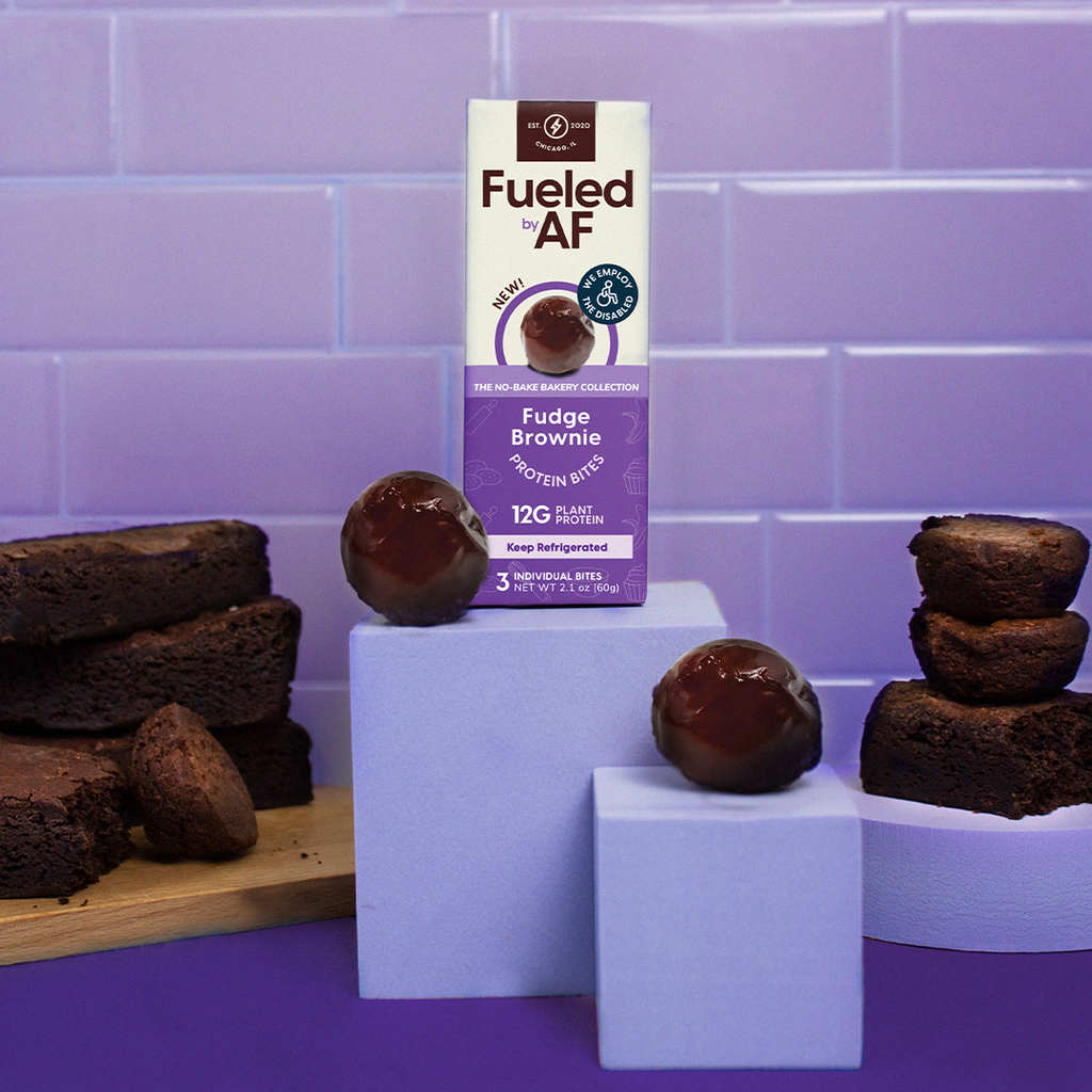 Artistic Product Photo of Fudge Brownie Protein Bites with a purple background next to brownies.